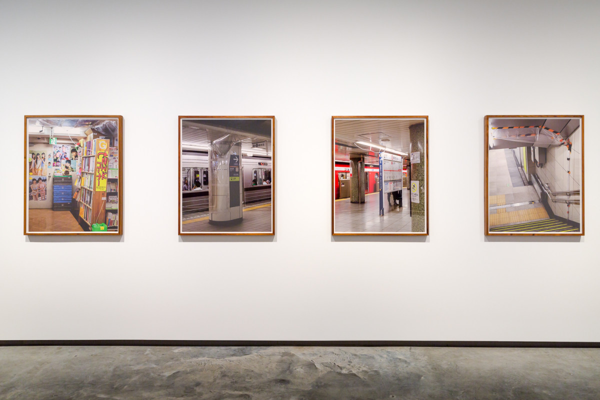 Four framed photographs hang on a white wall.