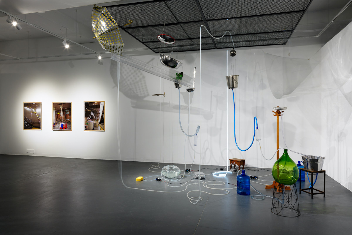 Various objects are joined by plastic pipes containing water, to create one large suspended installation.