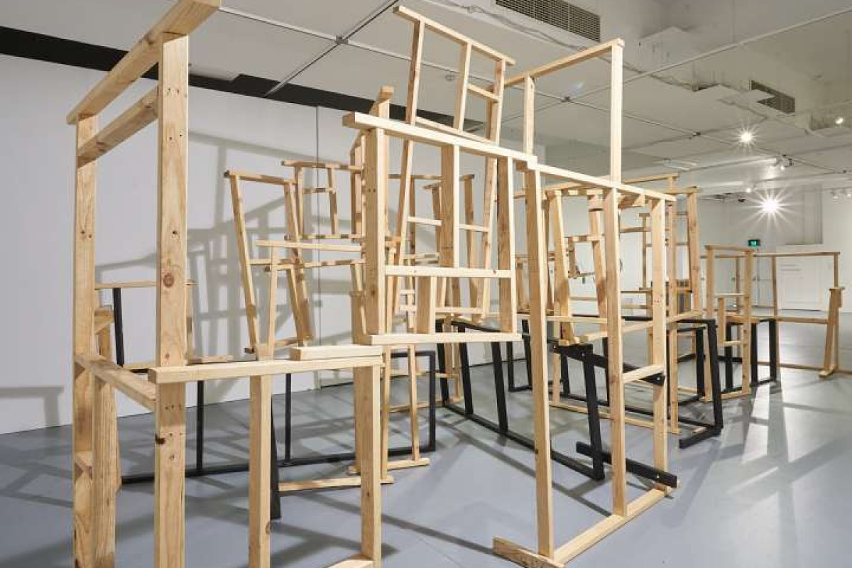 A large wooden sculpture , resembling a house frame, stands in the ACE main gallery.