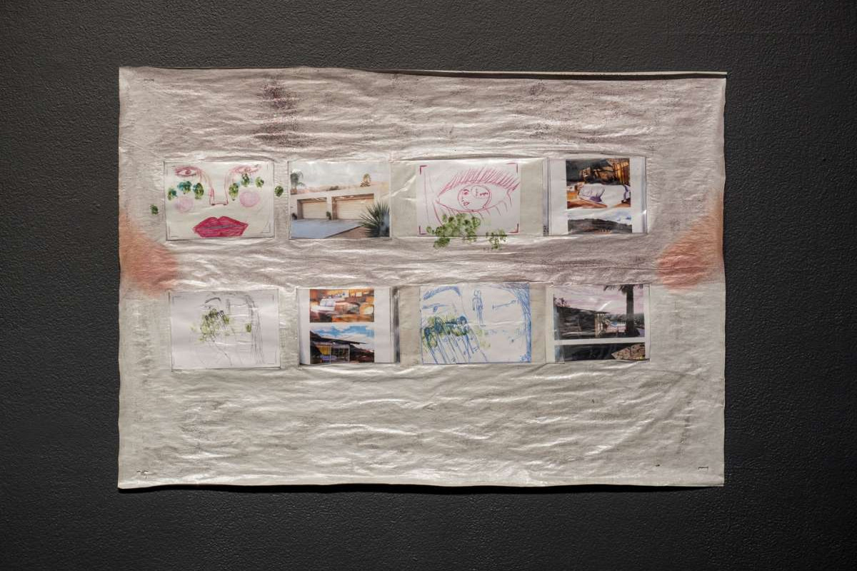 A series of eight collages hang in two rows on a piece of dirty white fabric.