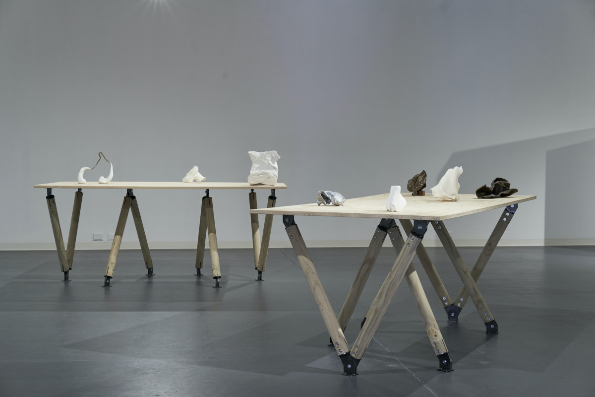 Two wooden tables with abstract black, white and grey sculptures.