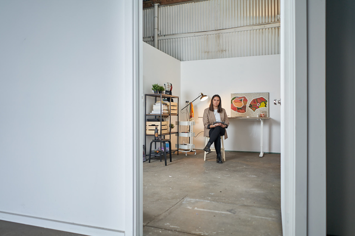 Carly Tarkari Dodd sits in studio with iPad on her lap.