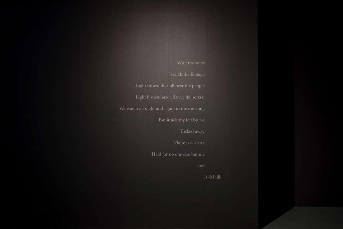 White vinyl letters on a black wall read: 