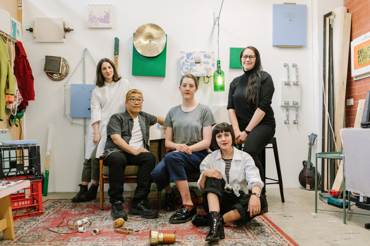 Studio artists Sundari Carmody, Anna Gore, Jonathan Kim, Oakey and Loren Orsillo sitting in Loren's studio surrounded by artworks.