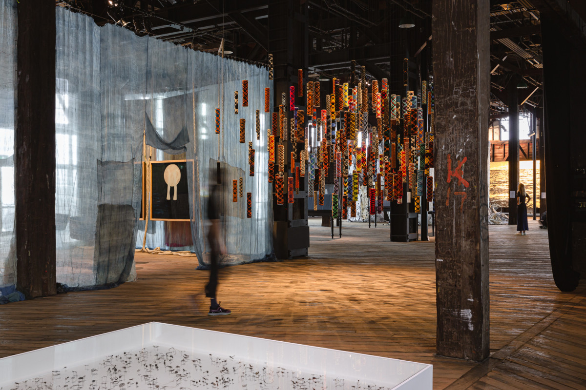 Many suspended cylindrical objects of many colours and patterns.