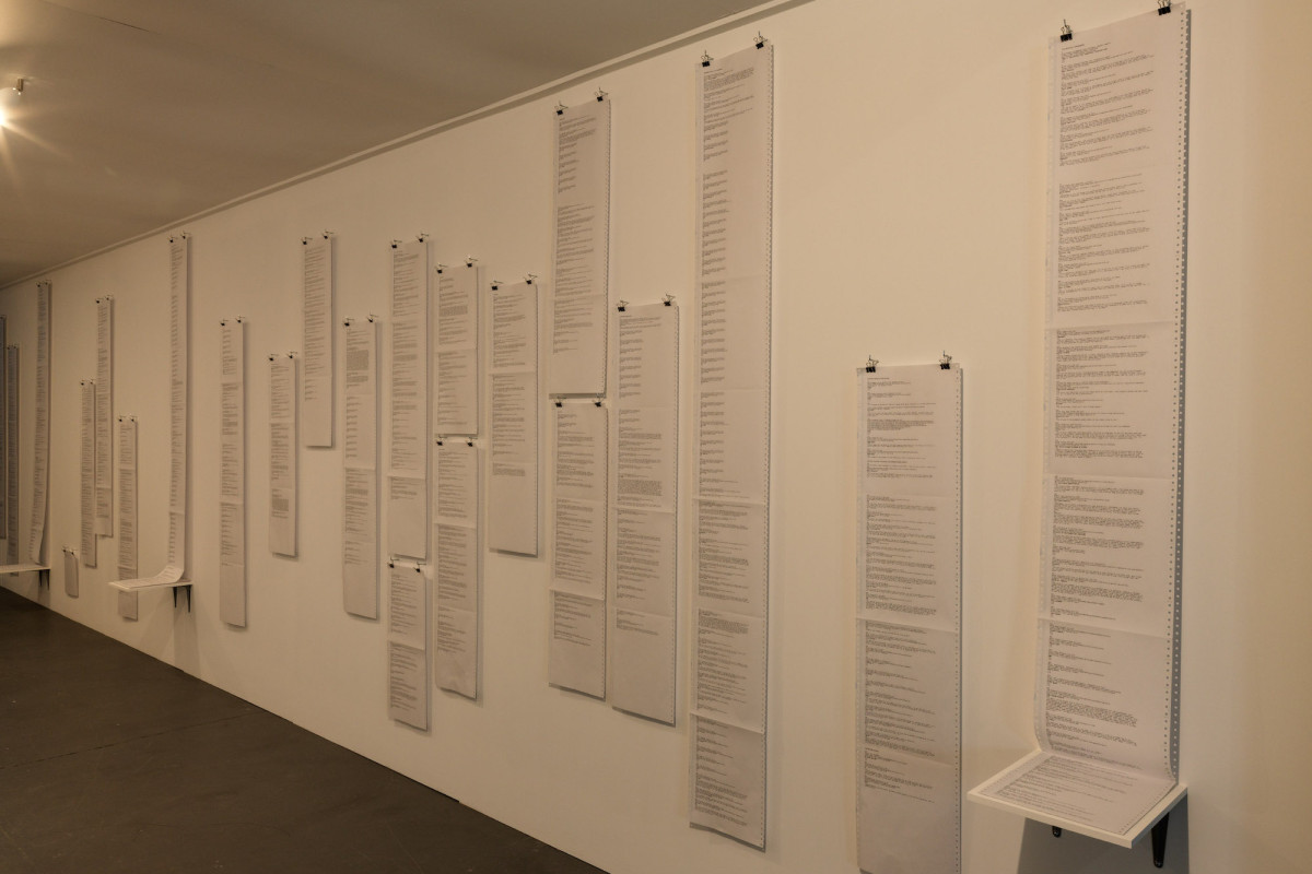 A wall with pages of writing by Roy Ananda.