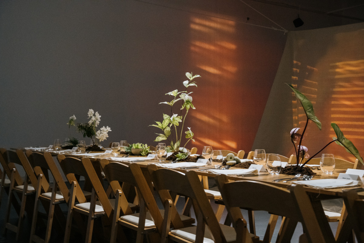 A long table adorned with floral installations. Allison Chhorn's tent-like installation is in the background.
