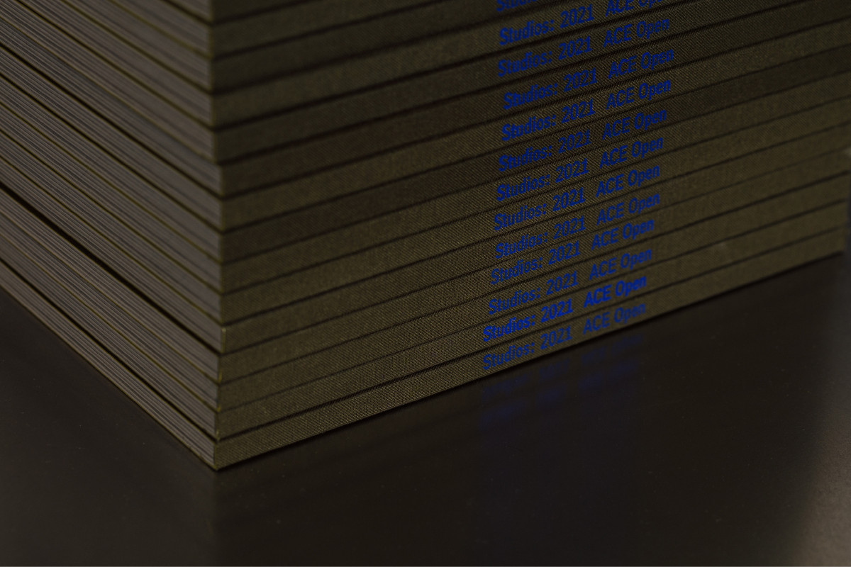 Photograph of 'Studios: 2021' catalogues stacked tall on the merchandise stand.