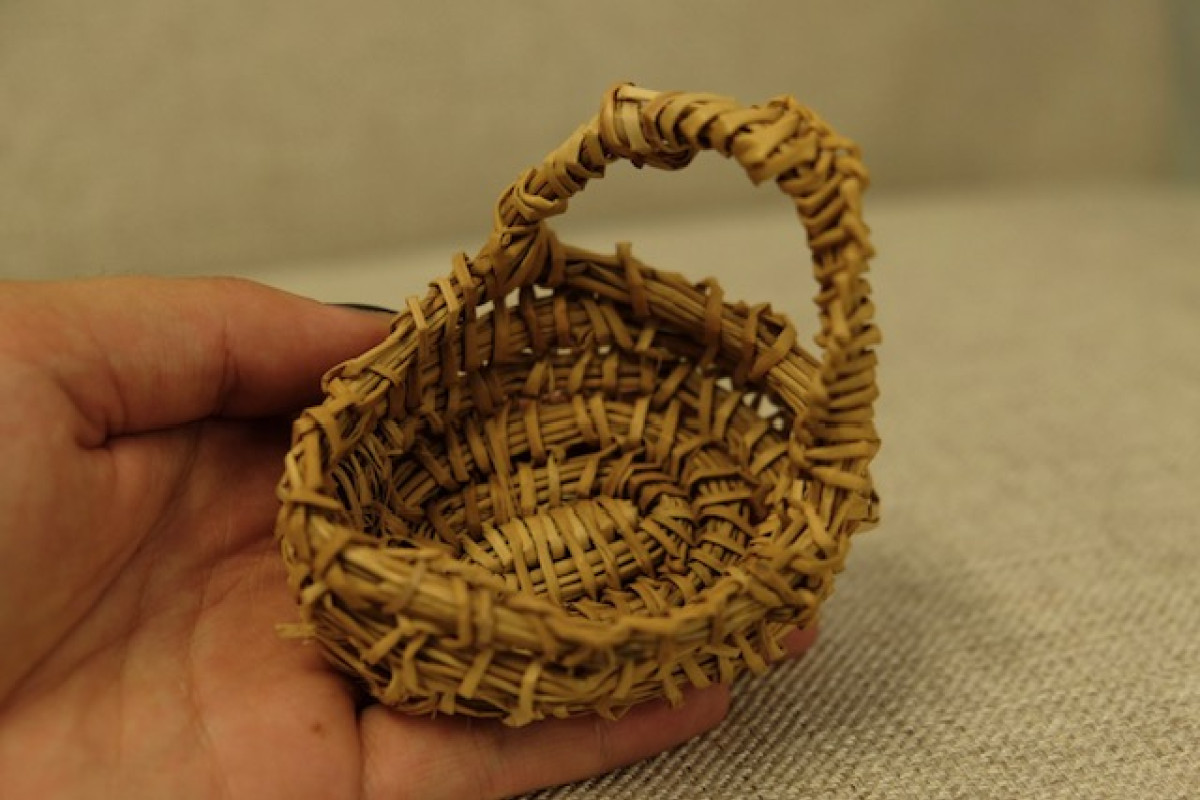 Small weaved basket held in a hand.
