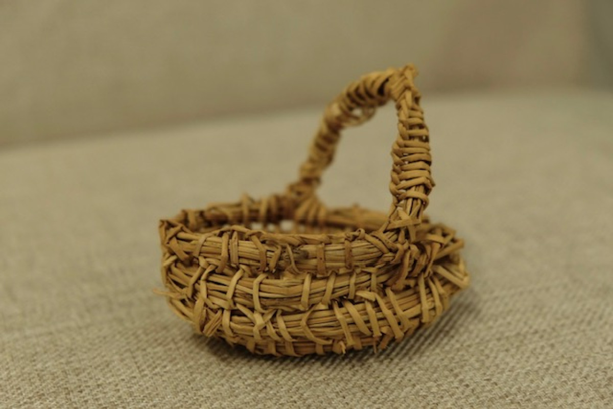 Small weaved basket sitting on linen.