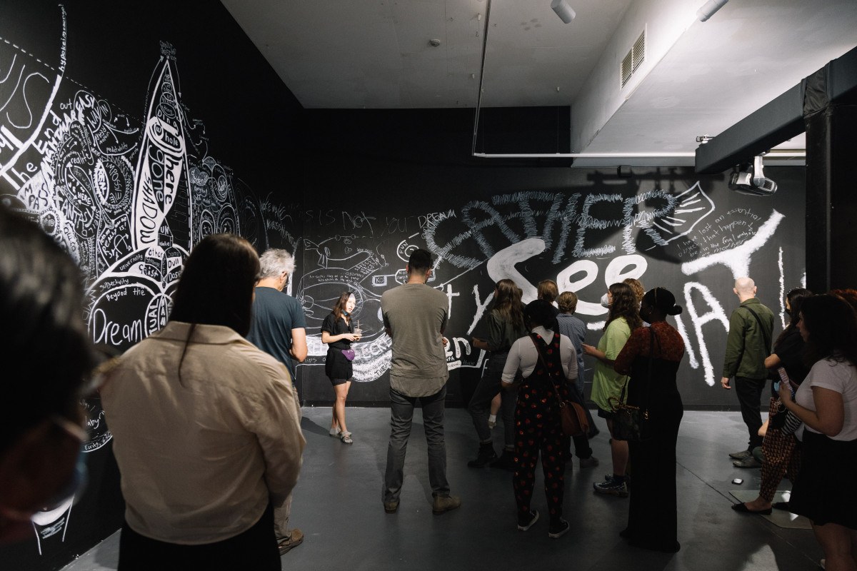 Artist Giselle Stanborough talks to audience inside the gallery space.