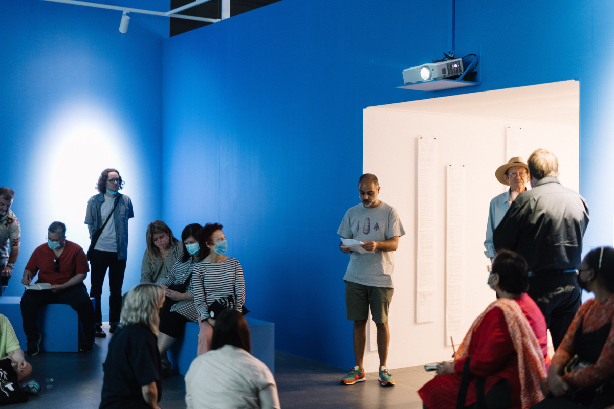 Artist Roy Ananda prepares to begin his talk, inside the gallery space.