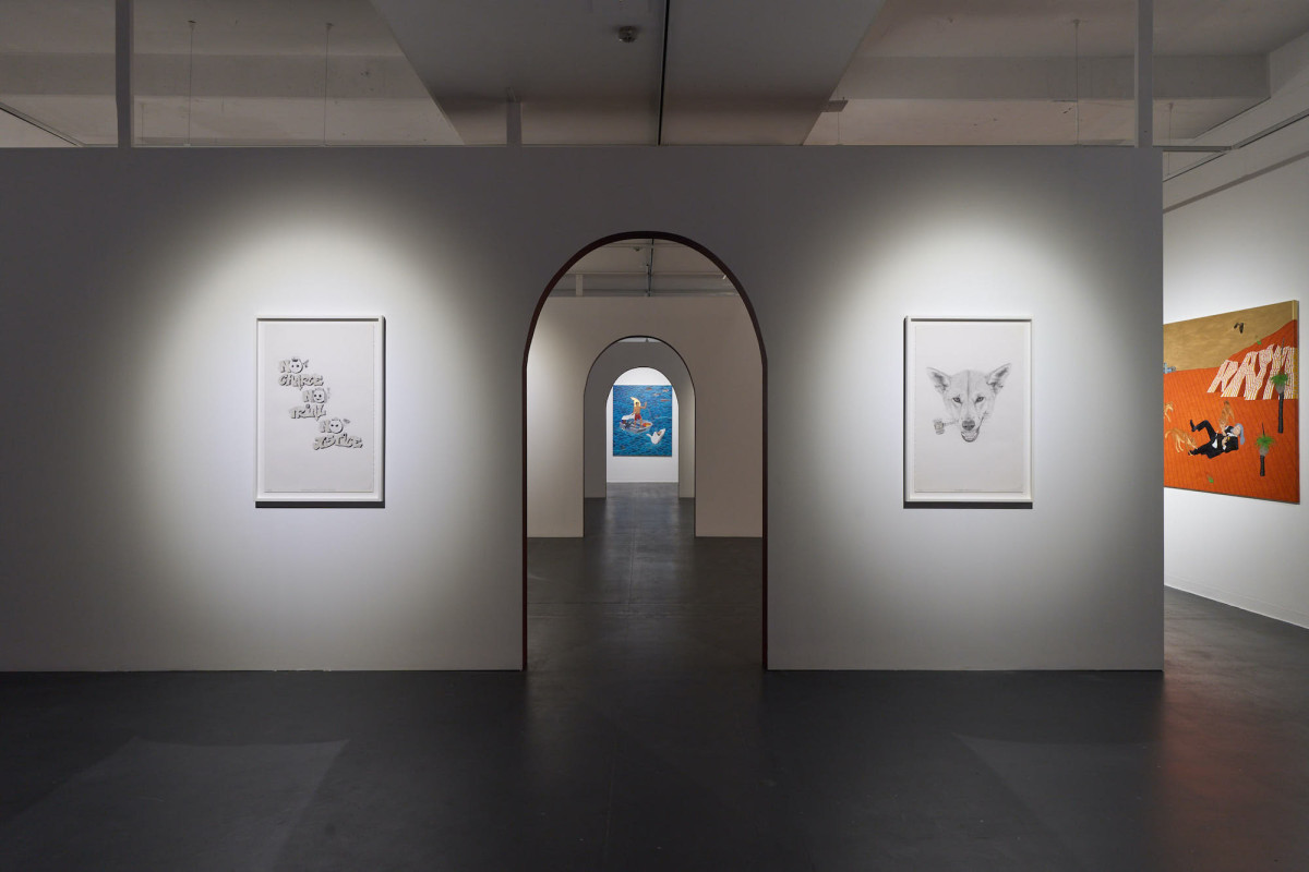 View of four artworks hanging on various walls within the gallery space.