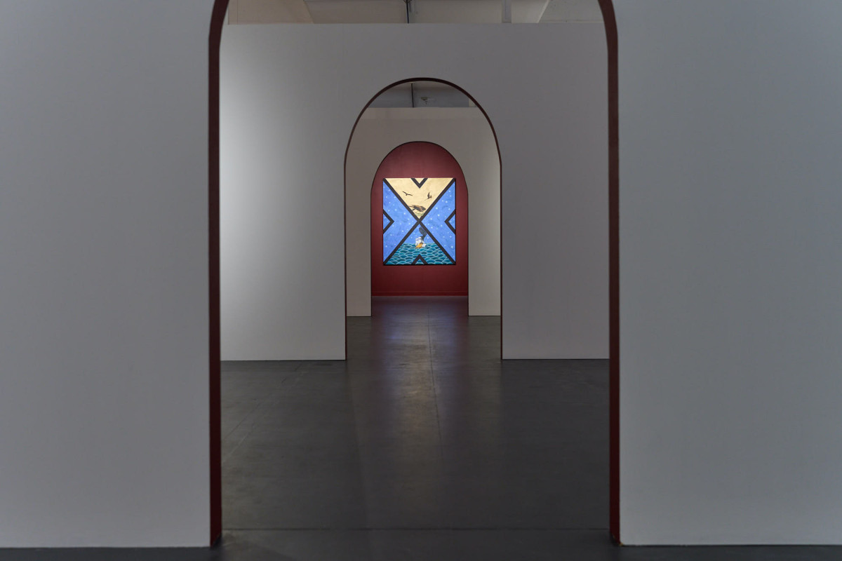View of one work hanging on the back wall of the gallery, through three archways.