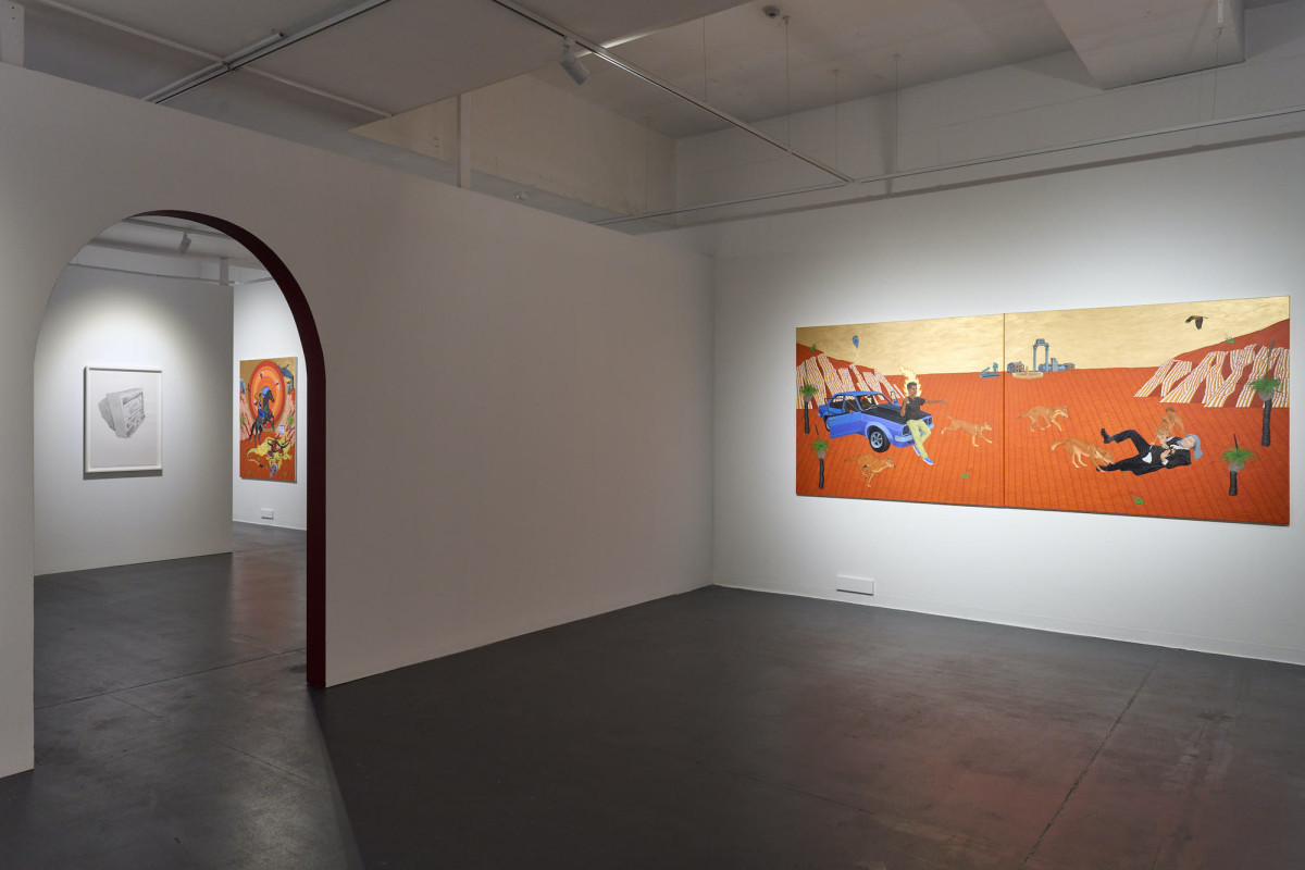 View of three artworks hung on various walls in the middle of the gallery space.