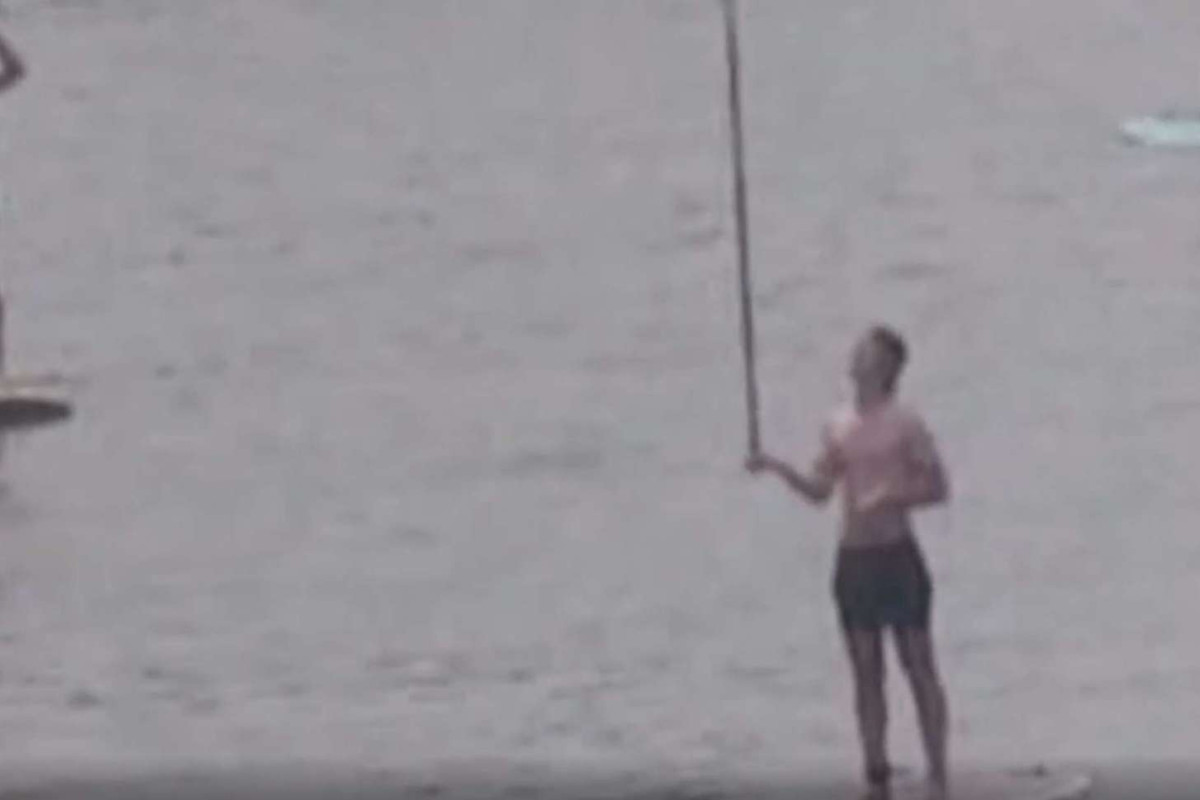 Close up of three people paddle boarding on the Murray River.