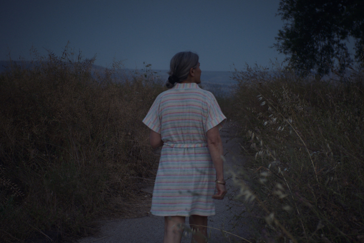 A woman walks in nature at night.