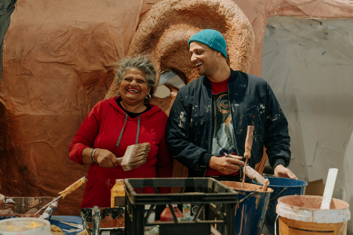 Kaspar and Koruna Schmidt Mumm working together on the ear of Rockamora. Both are laughing.