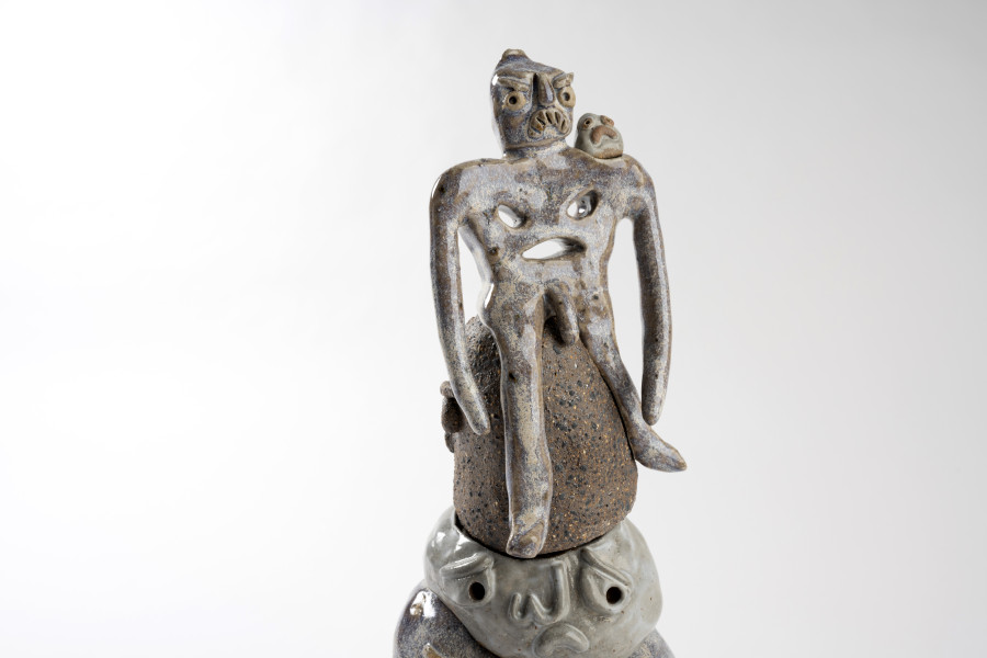 Photograph of human-like sculpture against a plain white background.