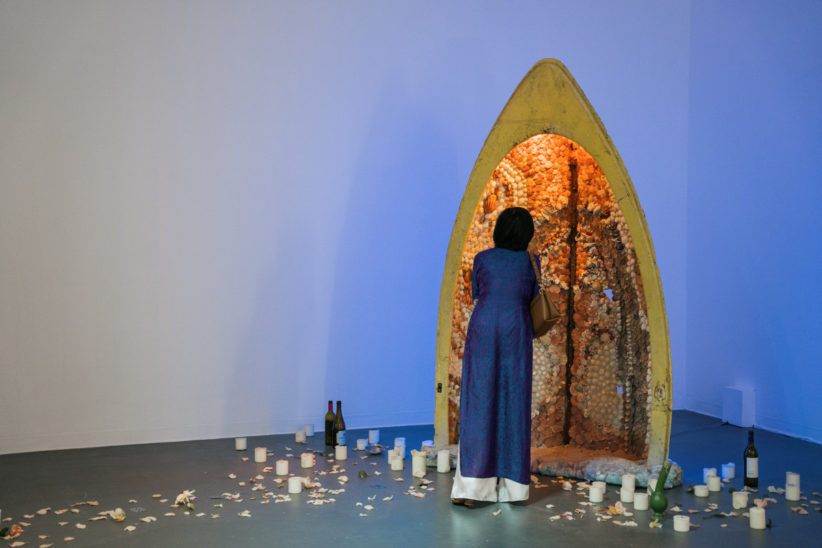 Teresa Busuttil's 'Sinner's Grotto' salvaged boat on opening night. A person looks inside.