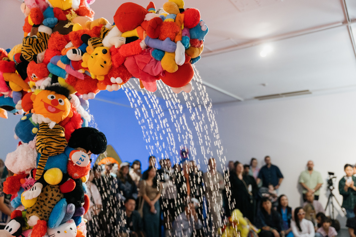 Truc's work up close on opening night. A tall crucifix which is engulfed in an array of dismembered soft toy limbs. Intermittently a water feature, the crucifix is activated producing streams from the crucifix into a pool of toy fish Koi.