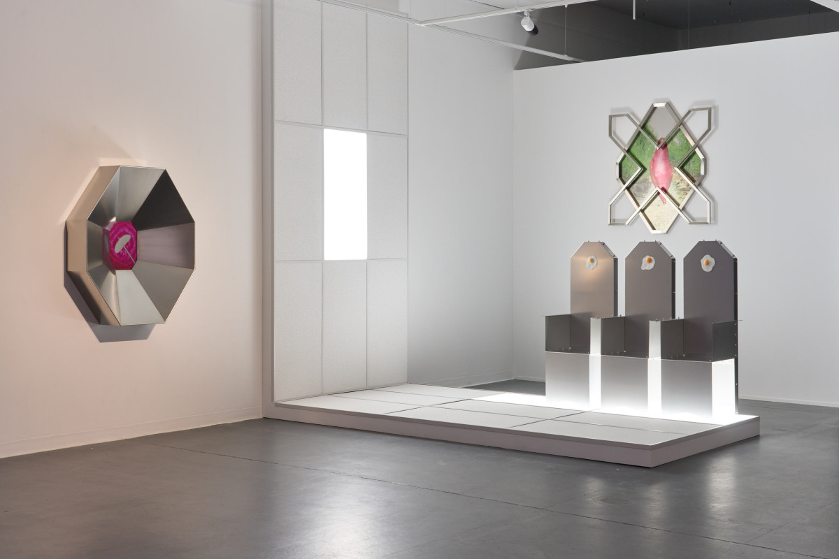 Installation view of 'Waiting to get cooked'. 'Waiting to get cooked' is a body of 3 sculptures: Austerity meal (rice on a needle with beetroot) is an aluminium octagon featuring a vinyl print at its centre; a grouping of 3 stainless steel chairs perched atop of a grid installation of an office-like ceiling and Starch Cross features a diamond shaped vinyl print of a sweet potato imposed over an image of a gravel footpath in a forest.