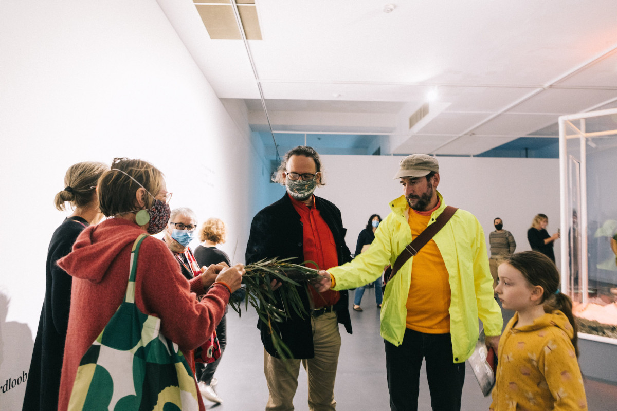 Audience participates in Welcome to Country in the gallery.