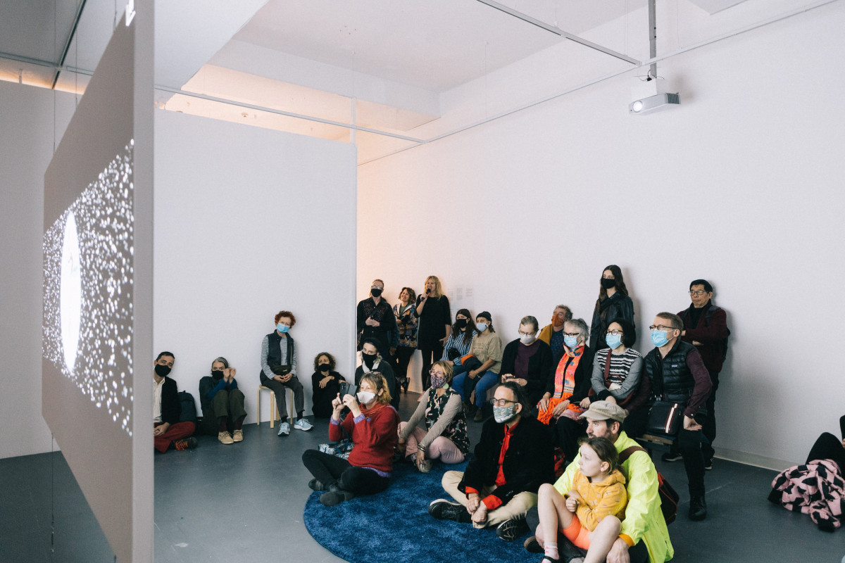 Audience watches film in the gallery.
