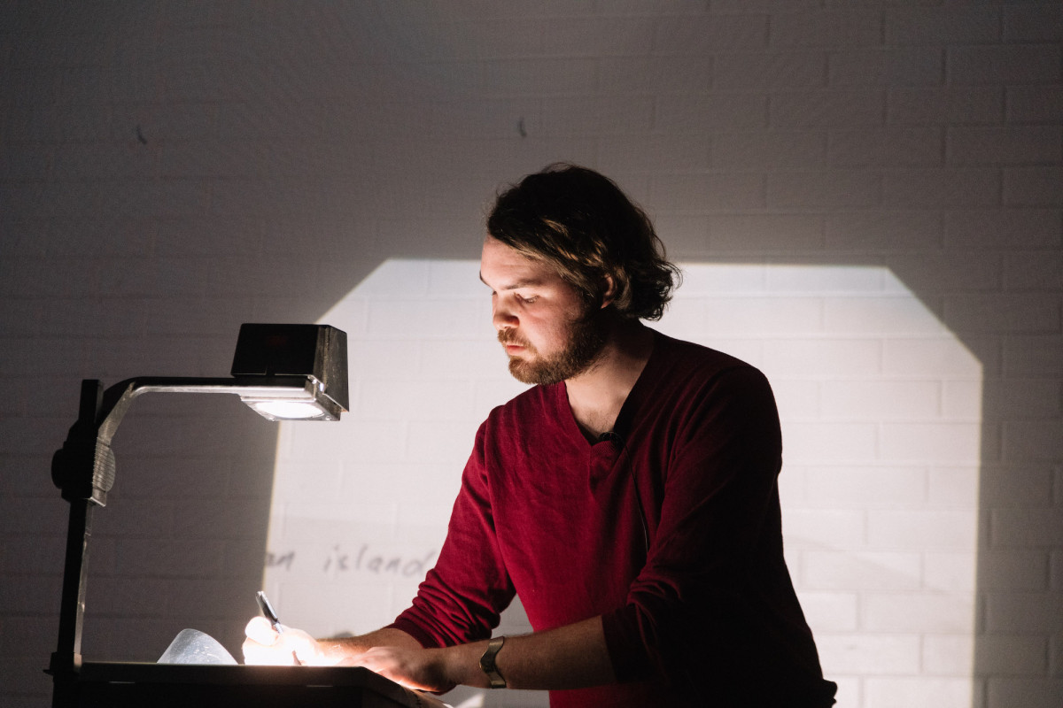A man writes on a projector.