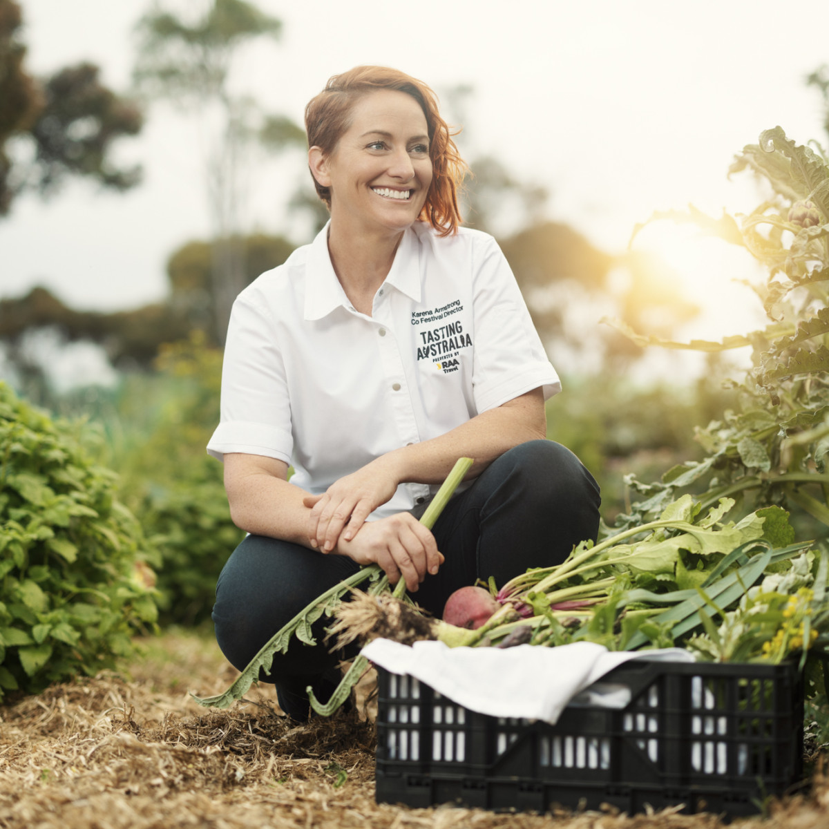 Karena Armstrong kneels in a garden. She smiles off-camera.