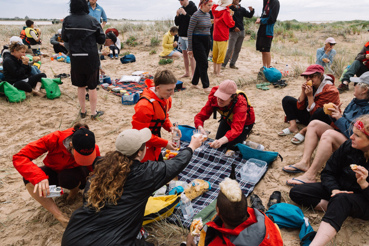 Group shares a meal in the dunes.
